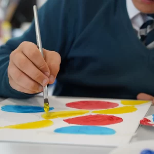 Student painting with yellow paint