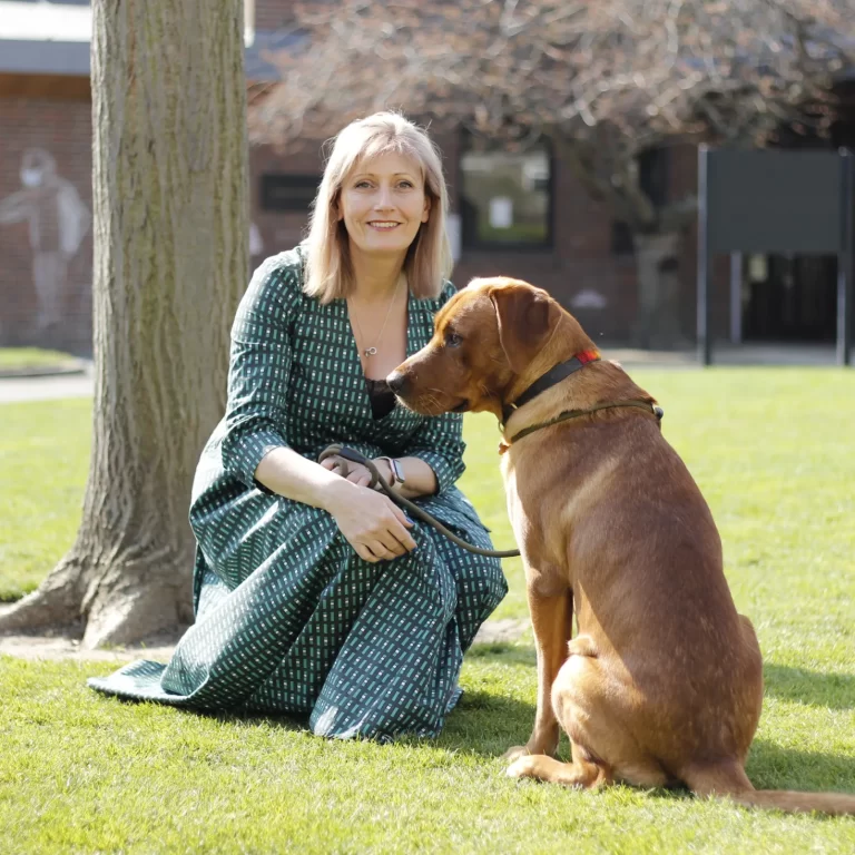 Lady and a dog sat on the grass