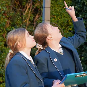 students pointing to the sky