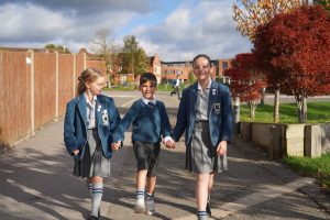 2 students holding hands and walking