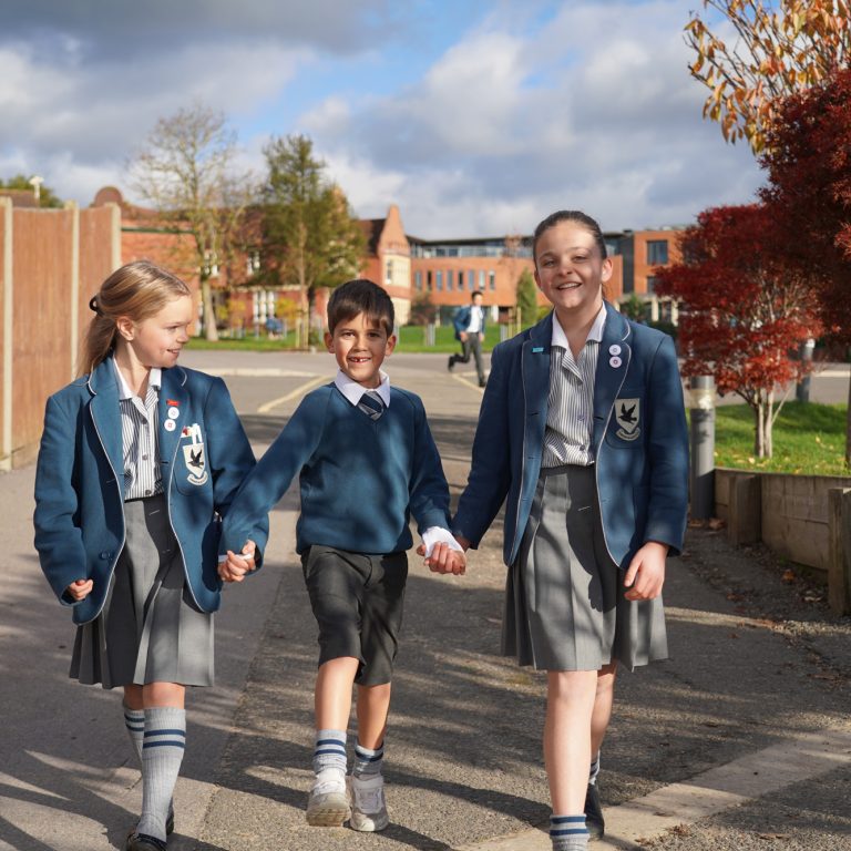 2 students holding hands and walking