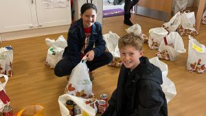students filling bags with food for charity