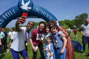 Mo Farah taking a selfie with students and teachers