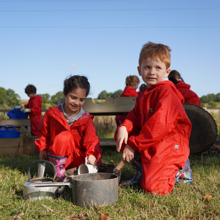 students next to cooking equipment laid out on the grass